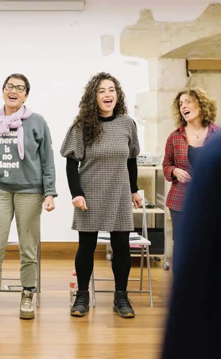 Tres mujeres cantando en clase de voz