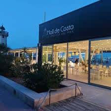 Fachada exterior del Moll de Costa al atardecer con iluminación cálida