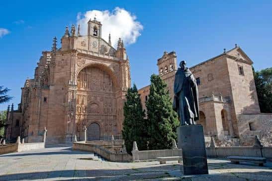 Vista exterior del Convento de San Esteban con fachada plateresca y estatua en primer plano