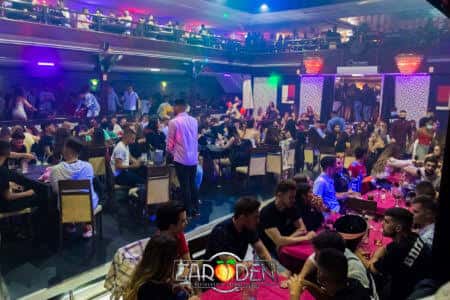 Vista general del interior de la discoteca con mesas y público