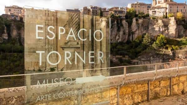Señalética exterior del Espacio Torner con vista al paisaje urbano de Cuenca
