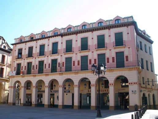 Vista frontal de la fachada principal de la Plaza Luis López Allué con sus arcos y balcones