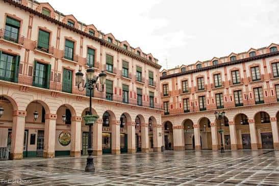Plaza Luis López Allué con suelo mojado reflejando los edificios y farolas