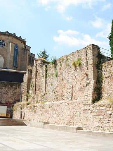 Muralla medieval junto a la Plaça del Carme con iglesia al fondo
