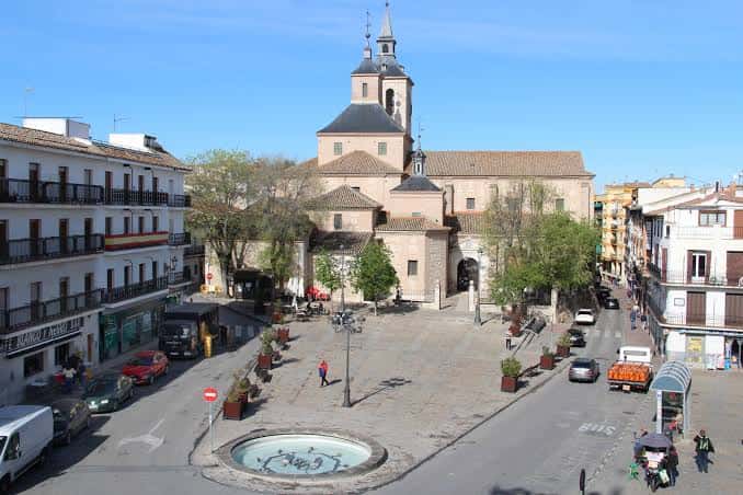 Vista aérea de la plaza con fuente central, edificios históricos y tráfico urbano
