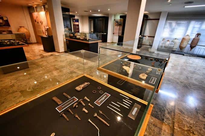 Vista general del interior del museo con múltiples vitrinas y piezas arqueológicas