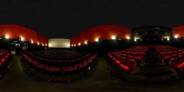 Vista panorámica de la sala de cine con butacas rojas y pantalla