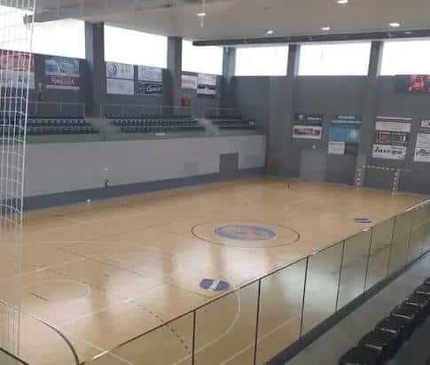 Interior del pabellón con pista de madera y gradas para espectadores