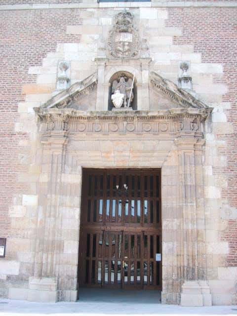 Detalle de la portada principal de la Iglesia de Santa Marina la Real con escultura de la Santa y escudo