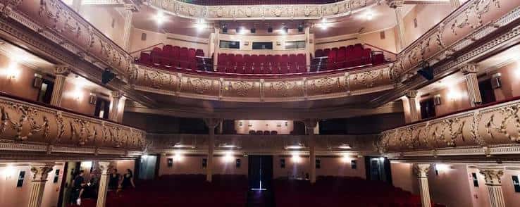 Interior del auditorio con balcones ornamentados y butacas rojas