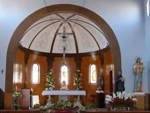 Vista del altar mayor de la Iglesia de Santa María Magdalena en Cofita, Huesca, con bóveda decorada y crucifijo central