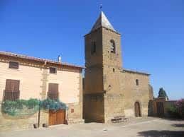 Fachada exterior de la Iglesia de Santa María Magdalena en Sipán, Huesca, con torre campanario bajo cielo despejado
