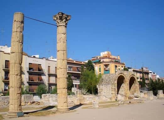 Columnas romanas y arcos del Fòrum de la Colònia bajo cielo azul