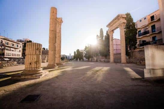 Vista panorámica de las ruinas romanas con columnas y arcos al atardecer