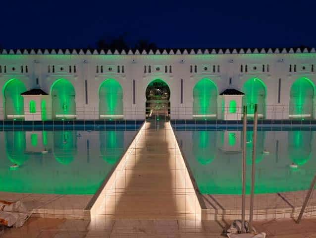 Fachada del Espai Cultural Moruno iluminada con luces verdes durante la noche