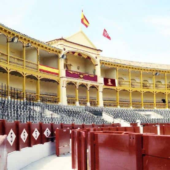 Interior de la plaza mostrando la grada y el palco presidencial con banderas