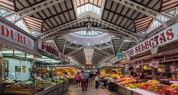Pasillo central del mercado con puestos de frutas y verduras