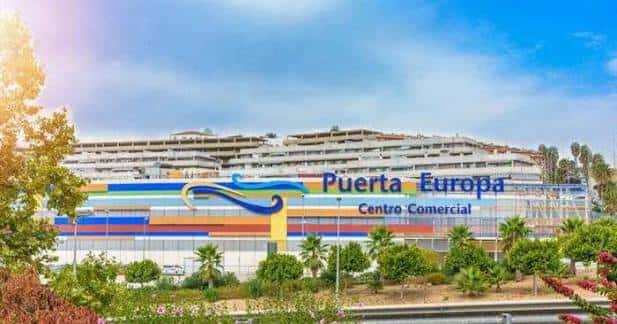 Fachada principal del Centro Comercial Puerta Europa con letrero colorido y entorno paisajístico
