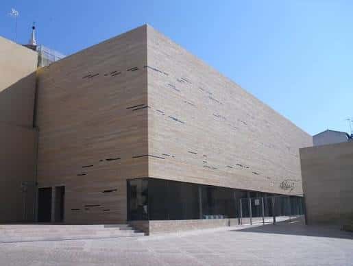 Vista exterior del Centro de Recepción de Visitantes con fachada de madera y cielo azul