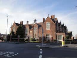 Fachada principal de Portsmouth Grammar School con arquitectura de ladrillo rojo y chimeneas