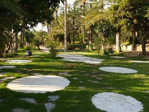 Sendero peatonal con círculos de piedra en el césped del Hort de Baix
