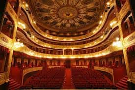 Vista panorámica del interior del teatro con cúpula decorada y butacas rojas