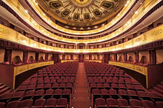 Interior del auditorio con balcones dorados y disposición simétrica de asientos