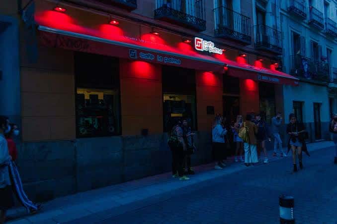 Vista exterior nocturna del Café La Palma con su distintiva iluminación roja