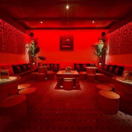 Sala VIP interior con decoración en tonos rojos y mobiliario moderno