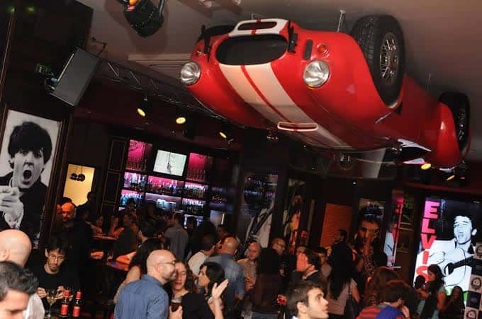 Evento en LongRock con coche rojo colgado del techo y ambiente festivo
