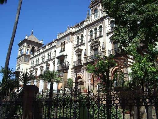 Fachada lateral del hotel con detalles arquitectónicos y jardines