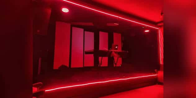 Escenario de Sala Taro con iluminación roja ambiental y teclado en el centro