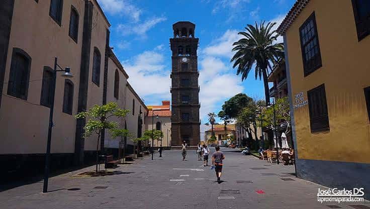 Torre del reloj en plaza principal con gente caminando