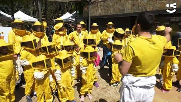 Actividad educativa con niños en trajes de apicultor en Casa de les Abelles