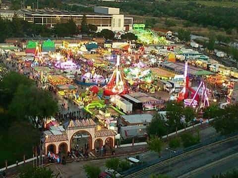 Vista aérea del recinto ferial durante una feria con atracciones y puestos