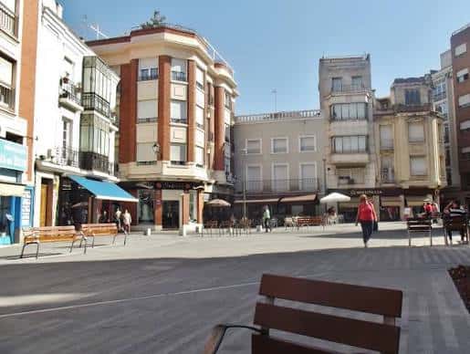Vista actual de la Plaza del Reloj con edificios históricos y bancos al aire libre