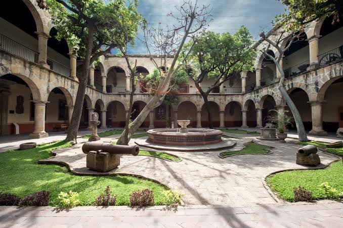Patio central con jardín, fuente y cañones históricos