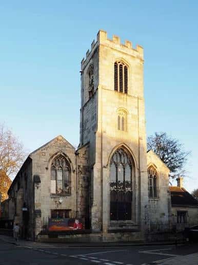 Vista exterior de la Iglesia de St Saviour en York con fachada de piedra y torre al atardecer