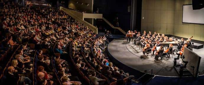 Interior del auditorio principal con escenario y butacas azules