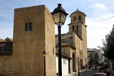 Vista de la iglesia desde la calle con farolas y árboles en primer plano