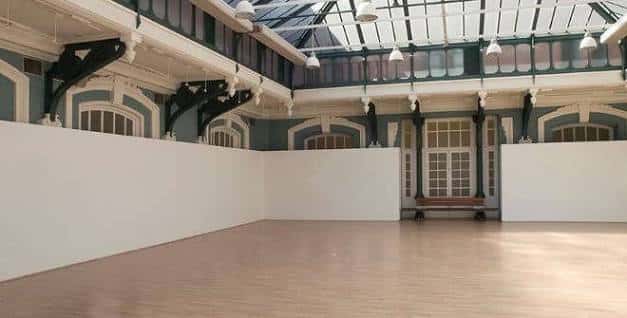 Sala de exposiciones interior con techos de cristal y paredes blancas listas para eventos