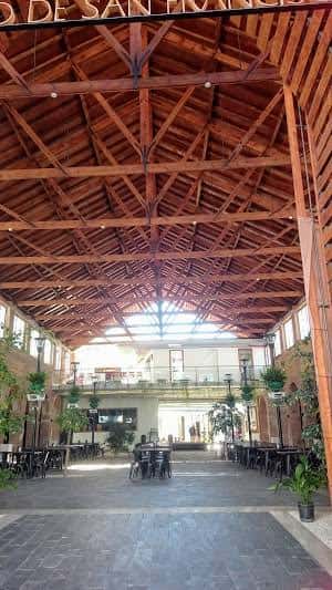 Interior amplio del mercado con techos de madera y espacios para eventos y reuniones