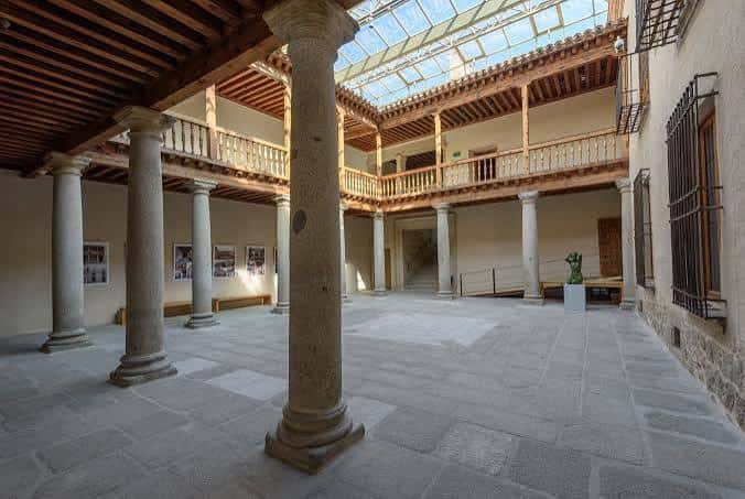 Patio interior del palacio con columnas de piedra y galería superior