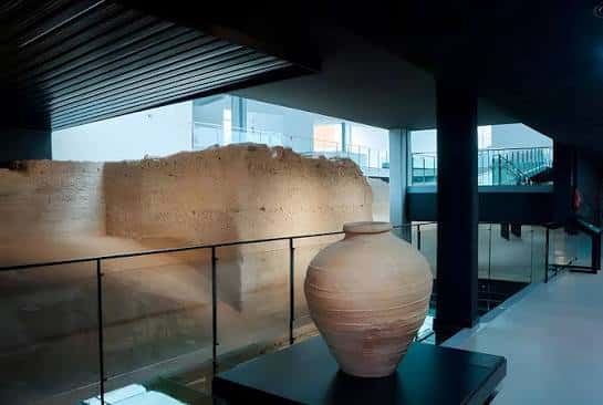 Exhibición de cerámica antigua junto a los restos de la muralla