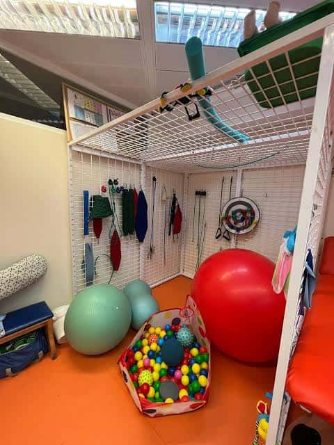 Sala de terapia ocupacional con material especializado y zona de juego