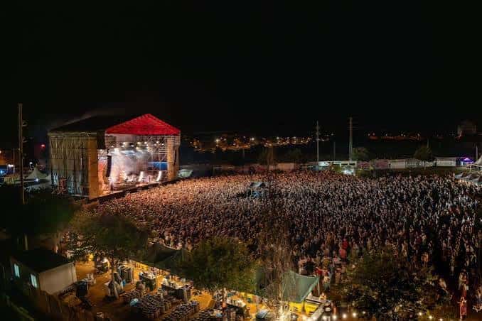 Vista aérea nocturna del concierto en el Parc de la Festa con el escenario iluminado y la multitud