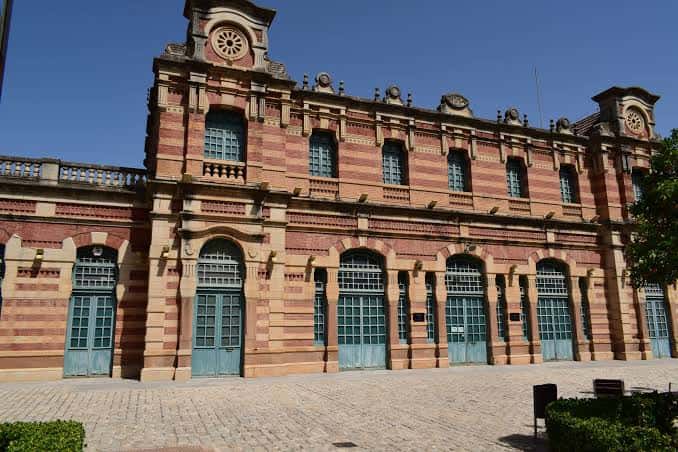 Plaza frontal de la Estación de Madrid en Linares, mostrando la entrada principal y el diseño simétrico del edificio bajo un cielo despejado