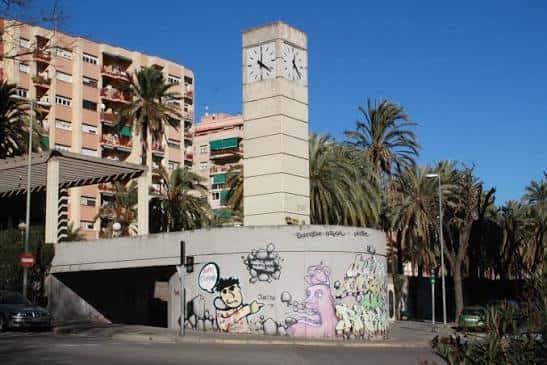 Vista de la Plaça de Trafalgar con el reloj emblemático y palmeras