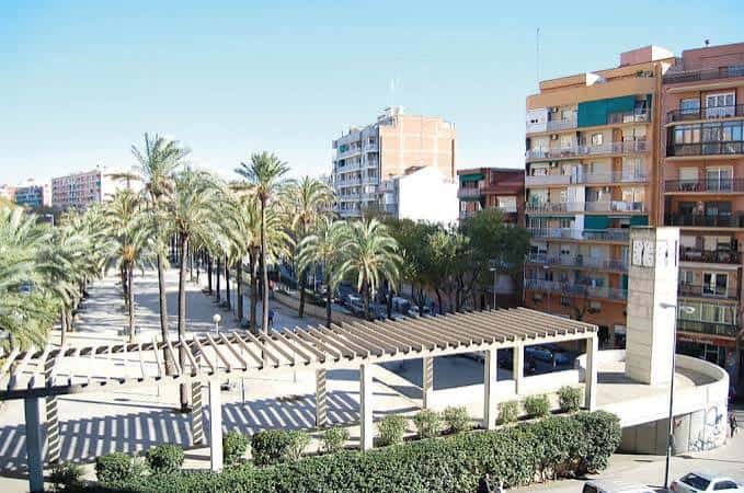 Vista panorámica de la plaza con pérgola y palmeras