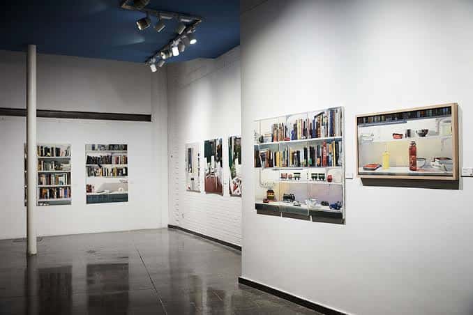 Vista del interior de la galería con obras de arte en las paredes